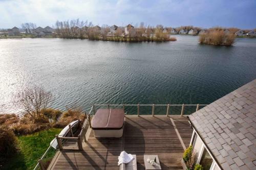 a dock with a boat in the middle of a lake at Summer Lake in South Cerney