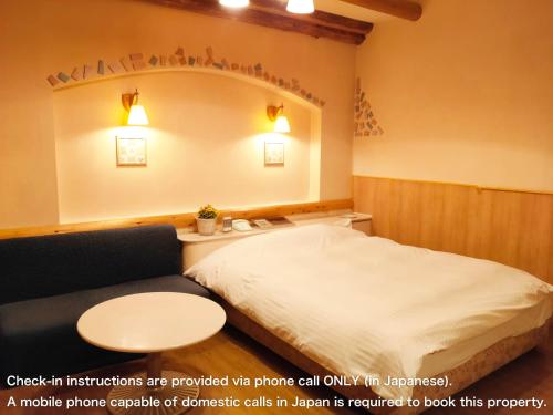a hotel room with a bed and a couch at アネックス艶 -大人専用- in Fuefuki