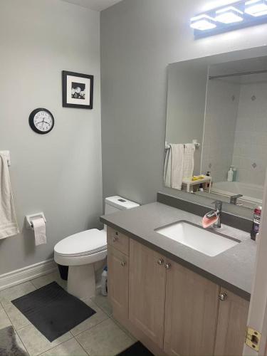 a bathroom with a sink and a toilet and a mirror at Tide Manor in Markham