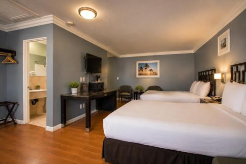 a hotel room with two beds and a desk at Big A Motel & Suites Near Disneyland Orange County in Orange