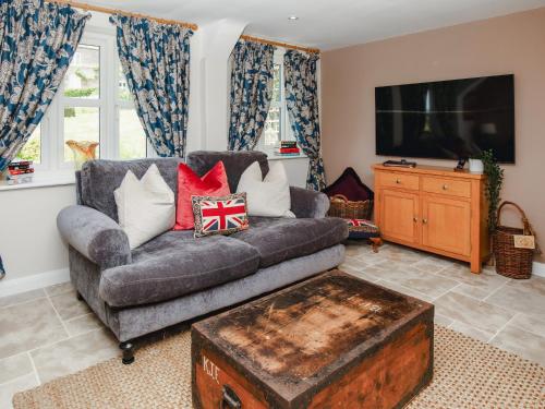 a living room with a couch and a flat screen tv at Thatcher's Cottage - Ukc3956 in Puncknowle