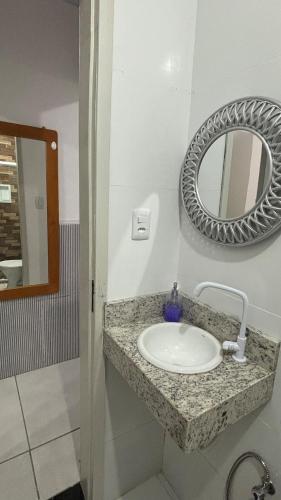 a bathroom with a sink and a mirror on the wall at Apartamento em Lauro de Freitas in Lauro de Freitas