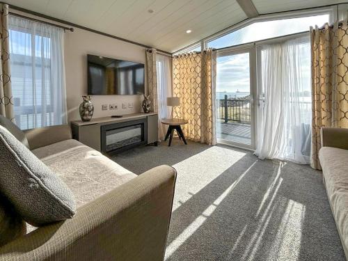 a living room with a couch and a large window at Marina Escape One in Peterhead