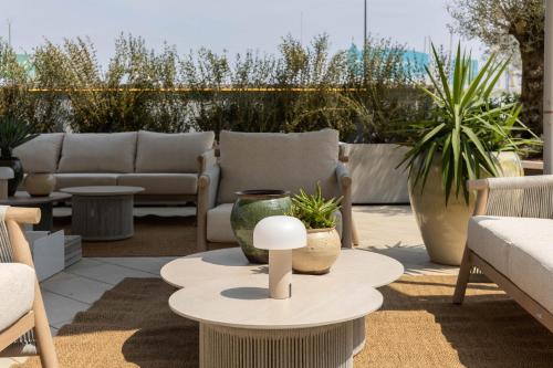 a patio with couches and a table and chairs at Alda Seaview Hotel in Cervia
