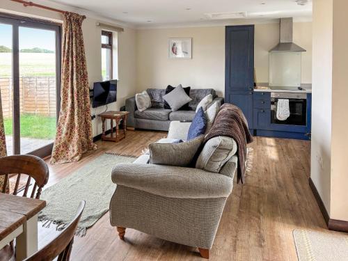 a living room with a couch and a table at Rose Chalet in Framlingham