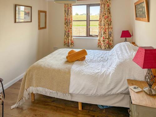 a bedroom with a bed and a window at Rose Chalet in Framlingham