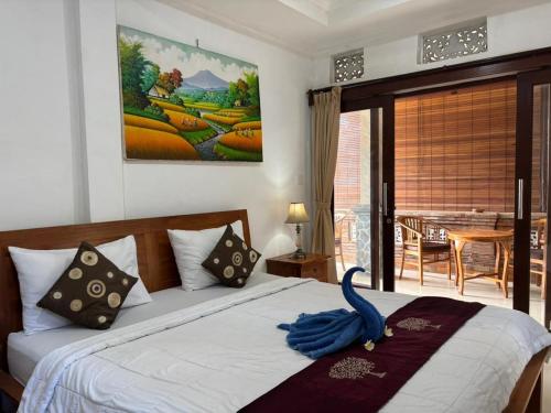 a bedroom with a bed with a blue towel on it at Wahadi homestay in Ubud