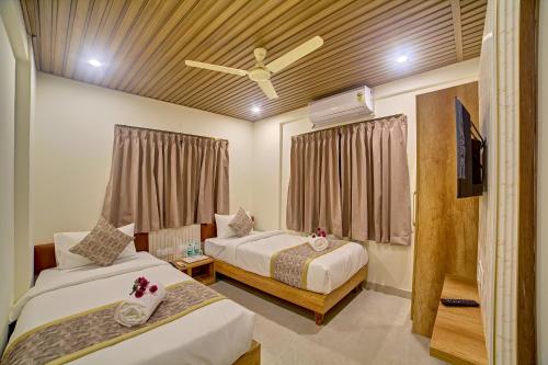 a bedroom with two beds and a ceiling fan at RedKEY Inn Transit Hotel Bangalore Airport in Bangalore