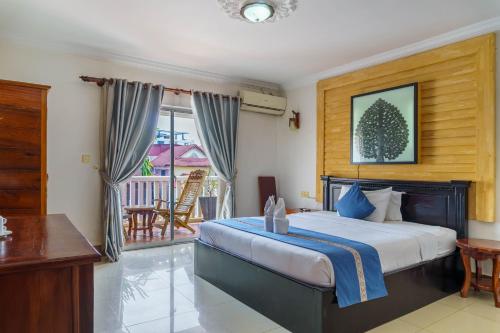 a bedroom with a large bed and a balcony at Bou Phanith Villa in Siem Reap