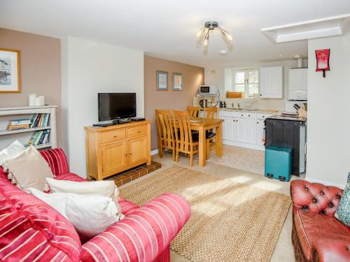 a living room with a couch and a kitchen at Keepers Cottage - Ukc3950 in Puncknowle