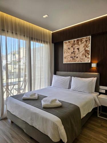 a bedroom with a large bed with towels on it at O!live Fully Equipped Apartments with Unique Design in Athens