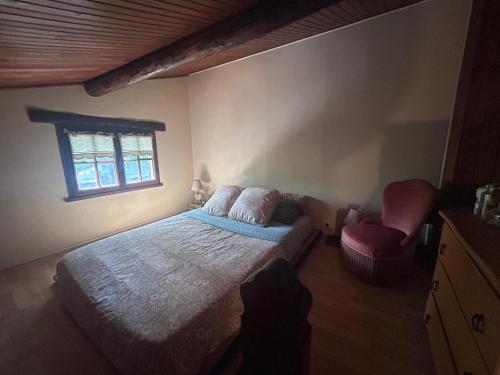 a bedroom with a bed and a chair and a window at Le Cabanon in Mane