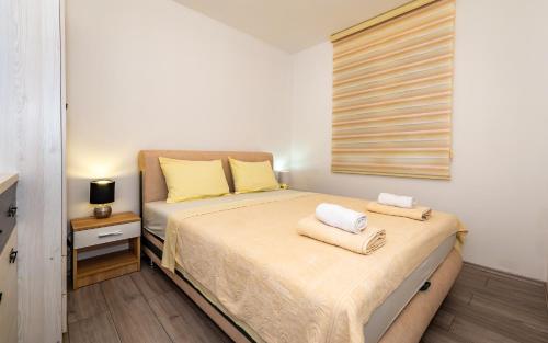 a bedroom with a bed with two towels on it at Silver Sunset 26 in Veliko Gradište