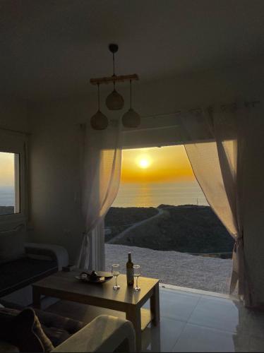 a living room with a table and a view of the ocean at Eagle's Nest Kythnos in Flampouria
