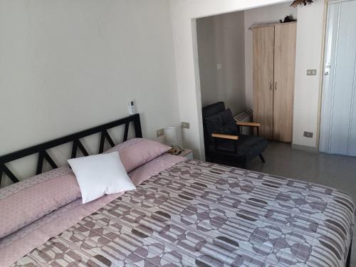 a bedroom with a large bed and a chair at Casa vacanze nel Parco della Majella in Montenerodomo