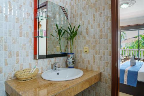 a bathroom with a sink and a mirror at Bou Phanith Villa in Siem Reap