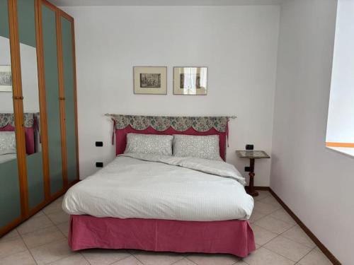 a bedroom with a large bed with a red headboard at Appartamento Nicoletta in Portolo