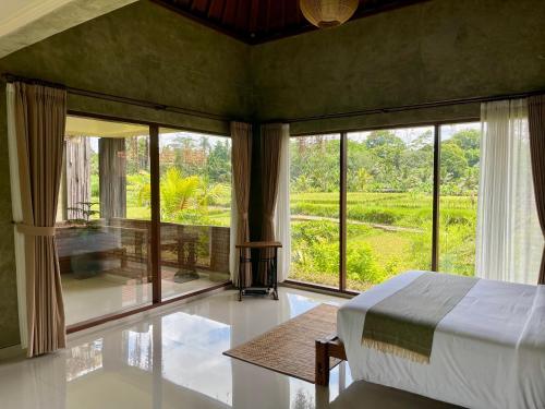 a bedroom with a bed and a large window at ElForest Villa Ubud, Payangan in Payangan