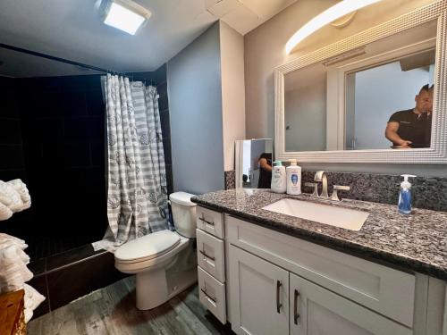 a bathroom with a sink and a toilet and a mirror at Duplex Close to HPU Waikiki Pool Terrace Laundry One and Half Bath for 15person in Honolulu