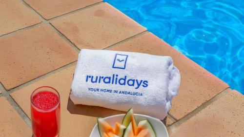 a table with a plate of fruit and a drink at Cortijo Noguera La Taha - Pitres by Ruralidays in Granada