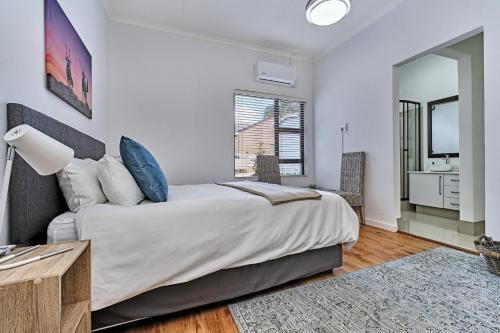 a bedroom with a large bed and a bathroom at 3 Kiaat Suites in Klerksdorp