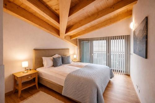 a bedroom with a large bed and wooden ceilings at ALPENNEST - Balcony & Sauna Access in Seefeld in Tirol