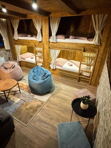 a room with three bunk beds and a table and chairs at Chata Biela Stopa in Tatranská Lomnica