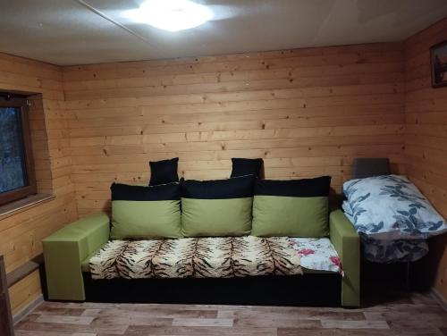 a room with a green couch in a cabin at Domček pri vode Pohoda in Teplý Vrch
