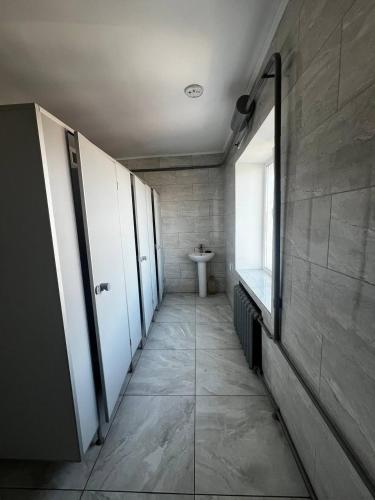 a hallway of a bathroom with a toilet and a sink at Хостел in Sumy