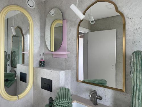 a bathroom with two mirrors and a sink at Sunday Apartamenty SPA Miraż in Ustronie Morskie