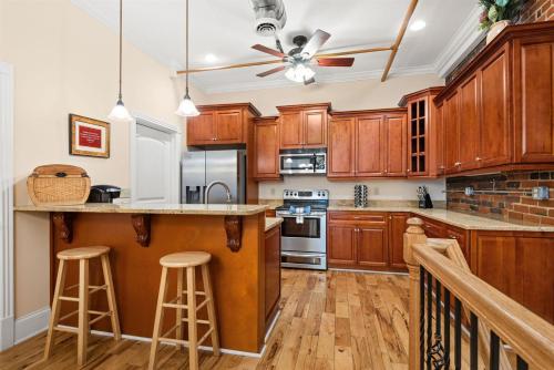 a kitchen with wooden cabinets and a bar with stools at The Dolly Printer's Alley Nashville- 2 Blocks to Broadway in Nashville