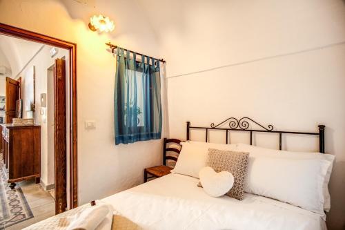 a bedroom with a white bed with a mirror at Terrazza Anvi Mare & Relax in Polignano a Mare