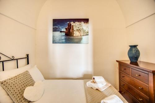 a bedroom with a bed and a painting on the wall at Terrazza Anvi Mare & Relax in Polignano a Mare