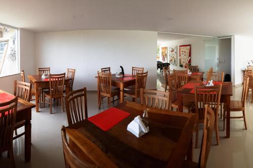 a dining room with wooden tables and chairs at Pousada Xerxes in Arraial do Cabo