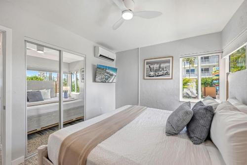 a bedroom with a large bed with a ceiling fan at Sea Turtle Bungalow - 1136-2 in Siesta Key