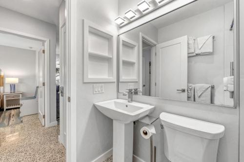 a white bathroom with a sink and a toilet at Sea Turtle Bungalow - 1136-2 in Siesta Key