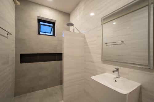 a white bathroom with a sink and a mirror at Sea Vibes Pool Villa in Ban Bo So