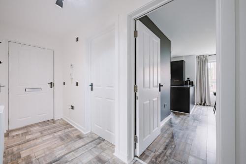 a hallway with white walls and a large mirror at SmartSleep Apartments in Glasgow