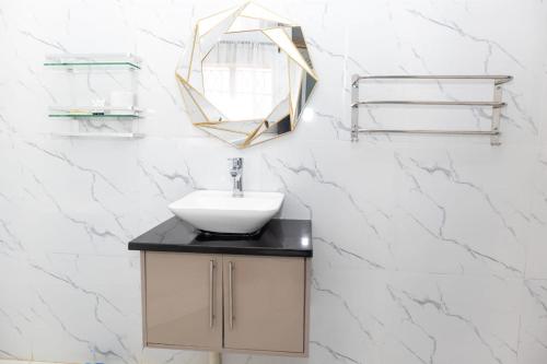 a bathroom with a sink and a mirror on a wall at Niyonest Guesthouse in Harare