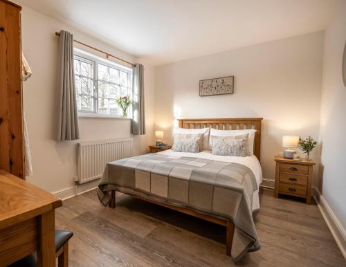 a bedroom with a large bed and a window at Greenacres in Kelsale