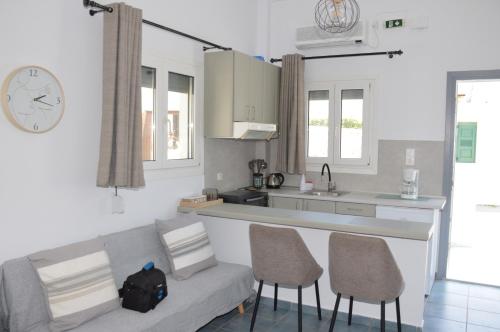 a kitchen with a couch and two chairs in a room at Giorgantis Studio II in Plaka Milou