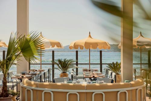 a restaurant with tables and a view of the ocean at COMO Le Beauvallon - Golfe de Saint-Tropez in Grimaud