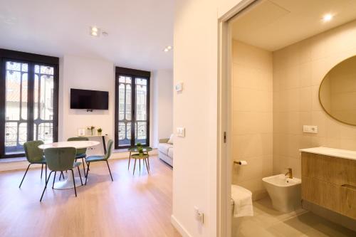 a living room with a table and chairs and a bathroom at Las villas de Manuel in Salamanca