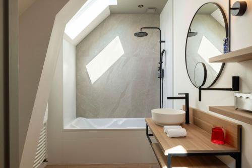 a bathroom with a sink and a bath tub at Hôtel & Spa de La Bretesche in Missillac