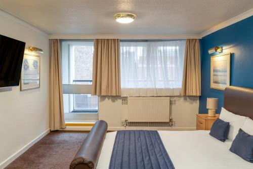 a bedroom with a bed and a large window at Britannia Hotel Coventry in Coventry