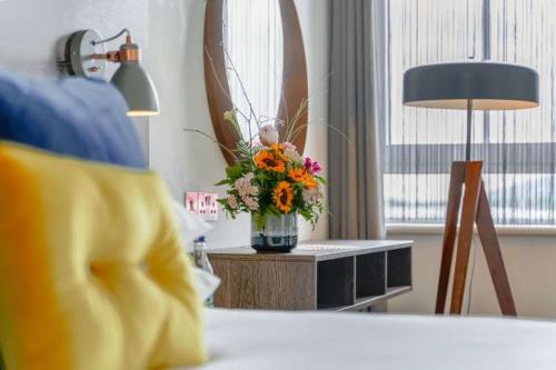 a vase of flowers on a table with a lamp at Base Dingle in Dingle