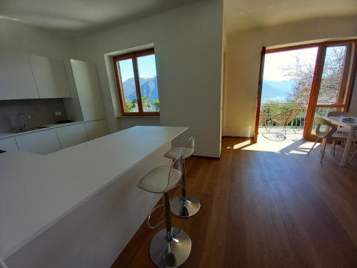 a kitchen with a large white counter with stools at Casa Vacanze Cael la Quiete in Riva di Solto