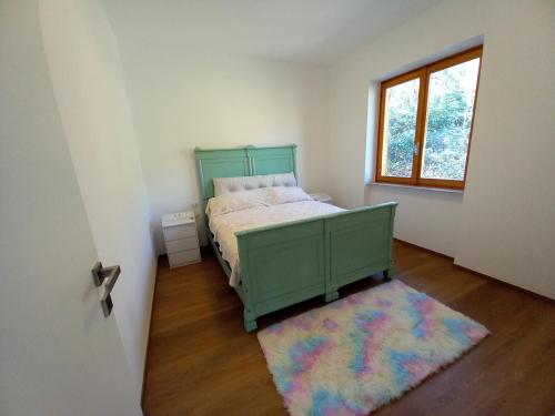 a bedroom with a green bed and a rug at Casa Vacanze Cael la Quiete in Riva di Solto