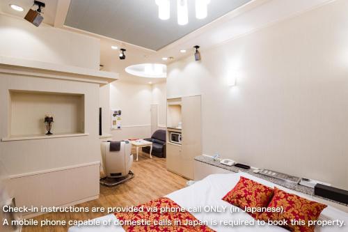 a bedroom with a bed and a living room at パティオアネックス -大人専用- in Fuefuki