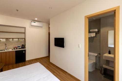 a bathroom with a bed and a sink and a toilet at Bluzen Hotel in Danang